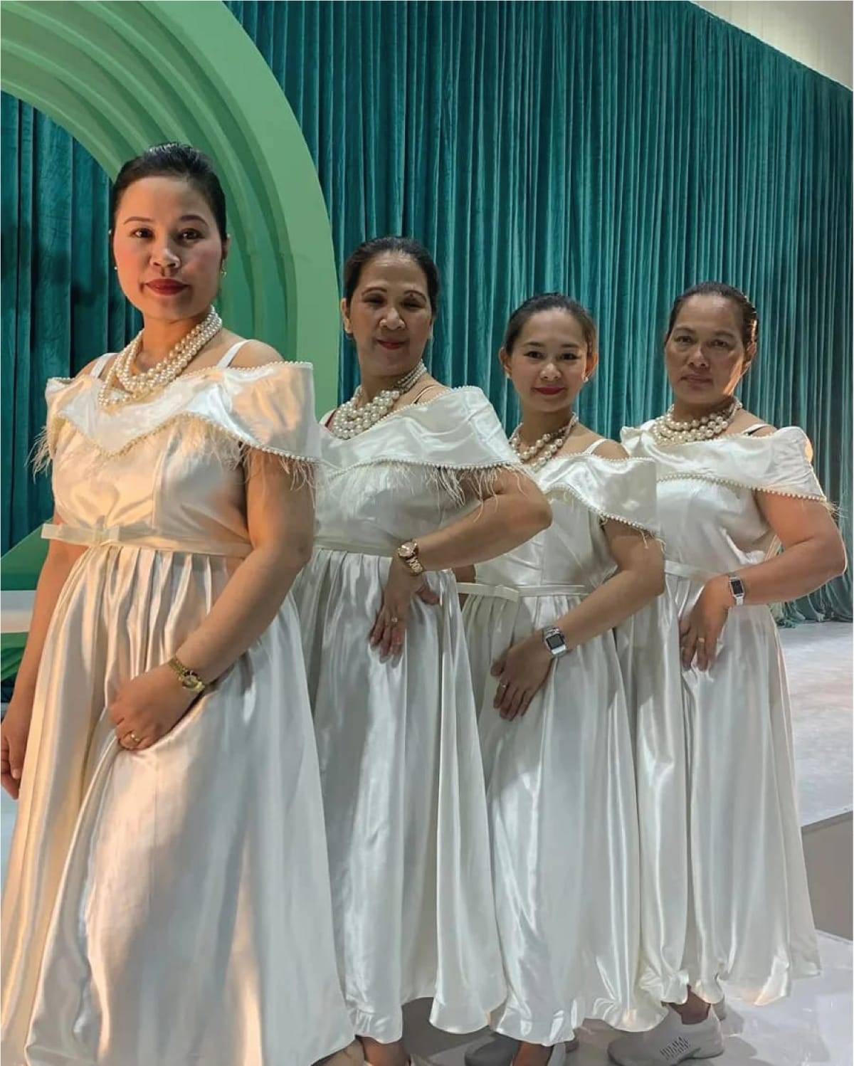 a group of women in white dresses at Arabic Coffee shop who serve the clients with love and care while presenting a cup Arabic Coffee
